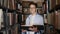 Portrait of a teen boy with a book in the library