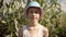 portrait of a teen boy in a hat on the background of a cornfield in summer, looking at the camera and smiling, cinematic