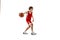 Portrait of teen boy, motivated sportsman training, playing basketball isolated over white studio background