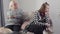 Portrait of teen Caucasian girl sitting with irritated facial expression as her mature grandmother shaking head