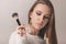 Portrait of teen model with stylish makeup holding contour brush