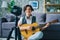 Portrait of teenage blogger recording video at home holding guitar smling