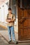 A portrait of a teenage boy, a student, stands next to the entrance to the school building