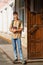 A portrait of a teenage boy, a student, stands next to the entrance to the school building