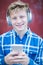 Portrait Of Teenage Boy Wearing Wireless Headphones And Listening To Music In Urban Setting