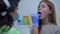 Portrait of teenage Caucasian girl opening mouth for medical examination as blurred doctor checking throat and tongue