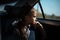 Portrait of teenage girl in the backseat of the car, looking at the window.