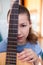 Portrait of teenage girl guitarist with fretboard of guitar, looking at camera