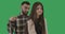 Portrait of teenage girl and young man combing her hair. Caucasian father hurting daughter and apologizing. Green screen