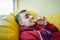 Portrait of a teenager lying on the couch and eating a delicious piece of pizza