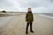 Portrait of teenager staing on coast of Baltic sea with lighthouse on background