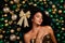 Portrait tempting beauty girl have golden bow in hair giving herself as a gift lying dreaming on x-mas toys background
