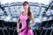 Portrait of a tennis player in a pink dress against the background of a sports arena. Olympic Games concept