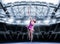 Portrait of a tennis player in a pink dress against the background of a sports arena. Olympic Games concept