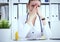 Portrait of tensed doctor sitting at the workplace in the hospital with hand on forehead in hospital