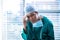 Portrait of tensed female surgeon sitting in corridor