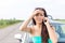 Portrait of tensed woman using cell phone against broken down car on road