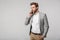 Portrait of thinking handsome man in jacket talking on cellphone