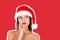 Portrait of thinking and reflecting girl in a Christmas hat. emotional woman in red santa claus hat Magazine collage style with