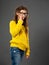 Portrait of thinking style schoolgirl in eyeglasses looking up on grey studio background in fashion clothing. Back to school. The