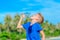 Portrait of a thirsty handsome boy drinking water on the desert