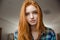 Portrait of thoughtful attractive redhead young woman in plaid shirt