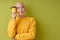 Portrait of thoughtful bald female holding cup of coffee in hands looking at side