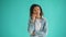 Portrait of thoughtful beautiful girl looking at camera on blue background