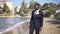 Portrait of thoughtful lonely African American groom in elegant suit strolling on sandy beach in sunshine. Sad depressed