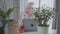 Portrait of thoughtful senior Caucasian woman sitting with laptop at home and looking at her gardening. Mature female