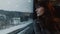Portrait of thoughtful young attractive European woman looking out of moving winter train on window seat slow motion.