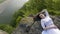 Portrait of thoughtful young bride in a white wedding dress lying on the rocks alone near the river