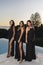 Portrait of three beautiful females in a party wearing different long black dresses