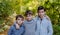 Portrait of three boys, brothers standing in forest.