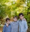 Portrait of three boys, brothers standing in forest.