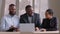 Portrait of three business partner young african man, mature elderly male leader and black ethnic woman sitting at table