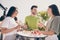 Portrait of three carefree funny friends hand hold champagne glass talking around table meeting outdoors