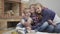 Portrait of three Caucasian children looking at camera and smiling. Cheerful girls and boy hugging at home in front of