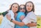 Portrait of three cheerful smiling women embracing during outdoor walking. They looking at the camera. Woman friendship, relations