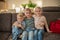 portrait of three children at home. brother and sisters sit on the couch hugging and smiling