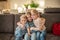 portrait of three children at home. brother and sisters sit on the couch hugging and smiling