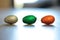 A portrait of three chocolat easter eggs in colorful tin foil lying on the floor in a row inside a house ready  to be found by