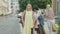 Portrait of three confident Caucasian women with shopping bags hitchhiking on town street. Elegant mid-adult ladies