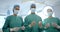 Portrait of three diverse male and female surgeons in operating theatre, slow motion