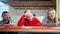 Portrait of three engrossed Caucasian friends cheering for football or soccer team sitting in pub drinking alcohol