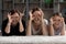 Portrait of three generations of women make glasses with fingers