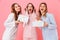 Portrait of three happy girls 20s wearing colorful striped leisure clothing screaming in excitement while holding gift boxes, iso