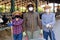 Portrait of three hardworking farmers in protective masks in a cowshed