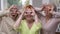 Portrait of three joyful women having fun grimacing standing in living room at home. Happy carefree Caucasian female