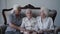 Portrait of three, mixed race grandmothers sitting on sofa, smiling emotionally